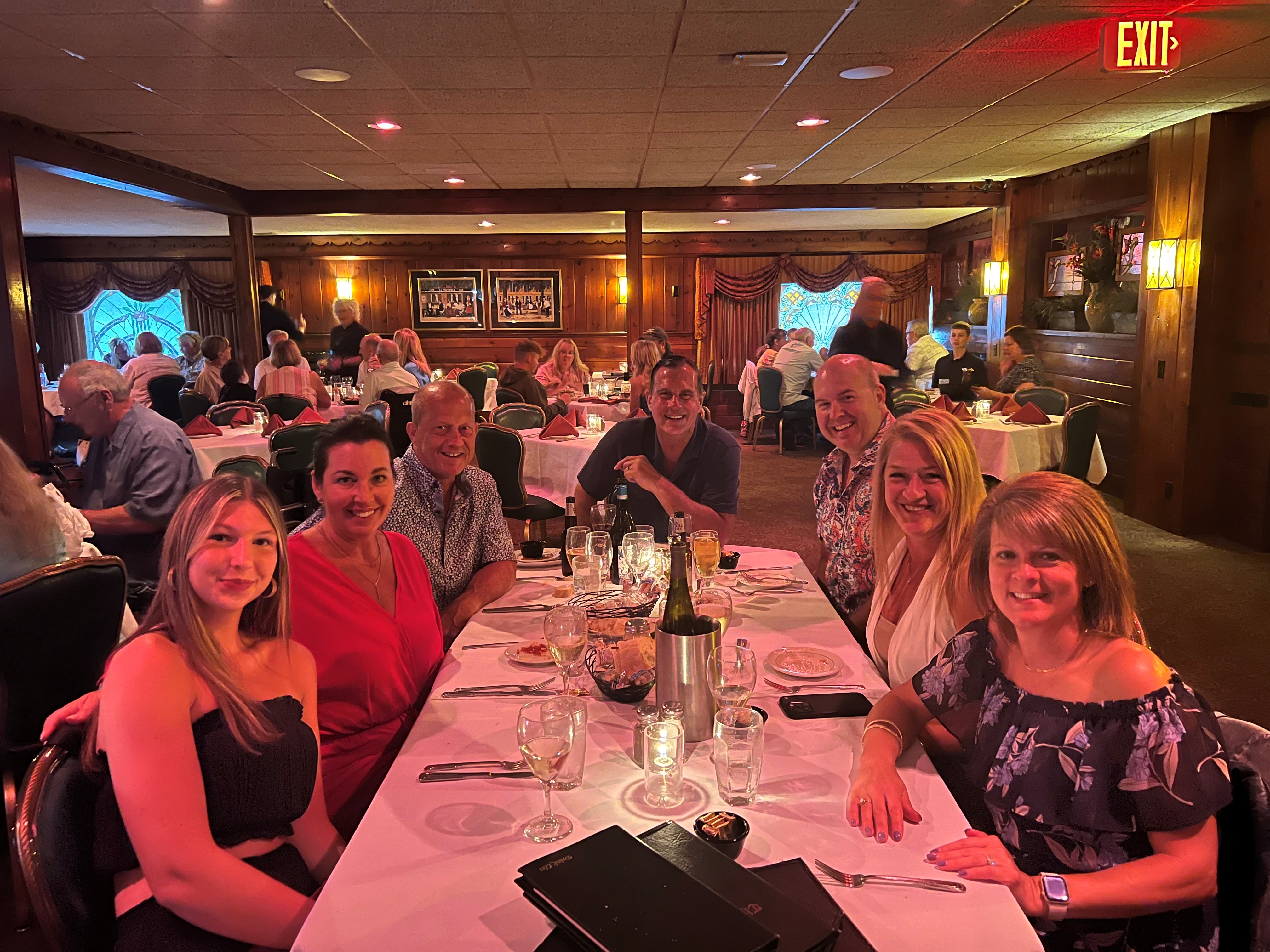 7 people around a table with glasses of water and place settings